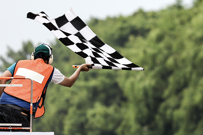 Man waving a black and white checkered race flag