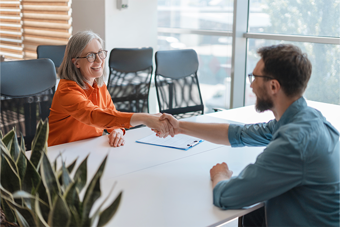 Smiling confident business people hand shaking working together in modern office. Meeting, teamwork, successful business. Job interview concept