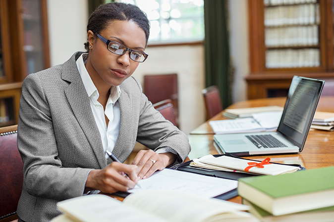 Young woman sitting at her desk doing legal research