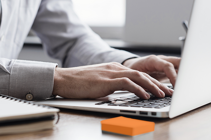 Man's hands typing on a laptop