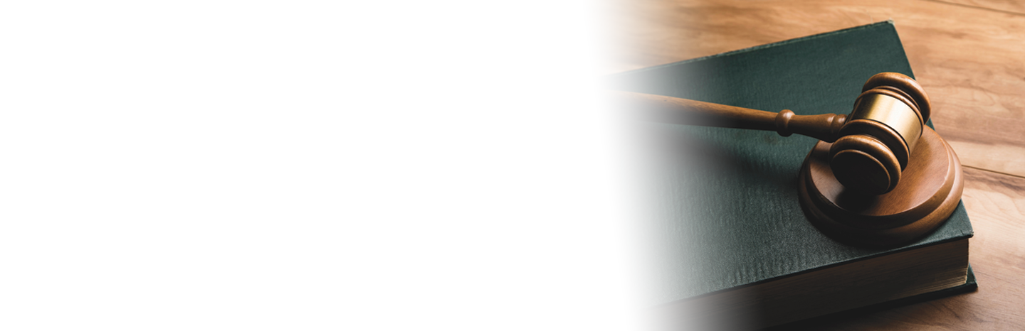 Judge's gavel sitting on top of a book on a desk of a