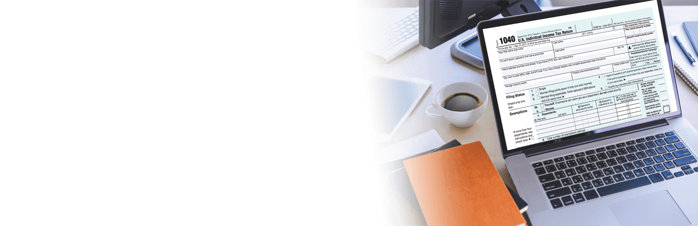 Laptop with 1040 tax form on it next to notebooks and a cup of coffee