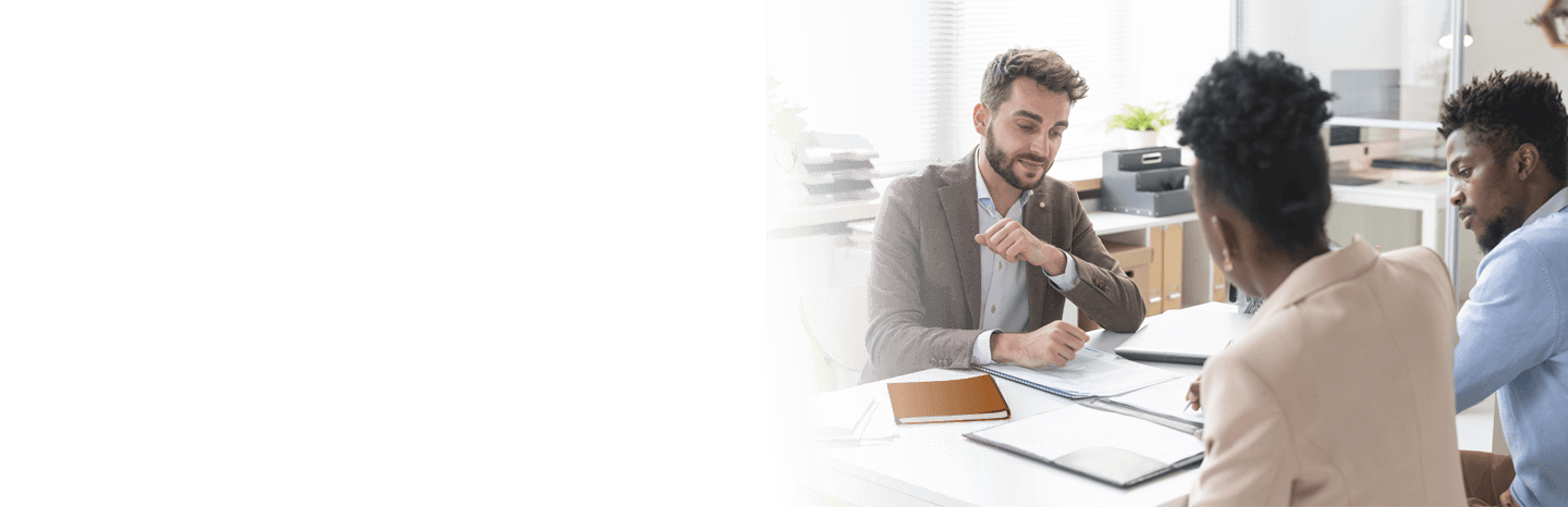 Young man going over documents with a couple in an office