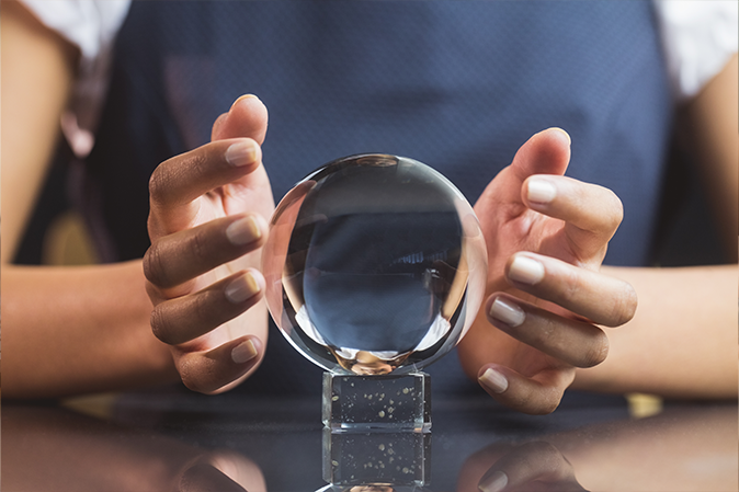 Woman looking into crystal ball on table