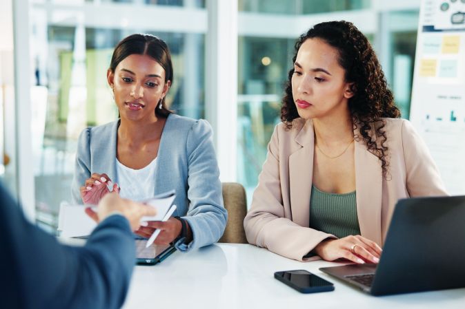 businesswomen in a meeting reviewing documents